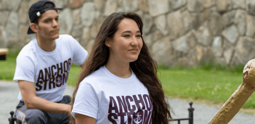 Two students wearing teeshirts that say "anchor strong" smiling on the quad